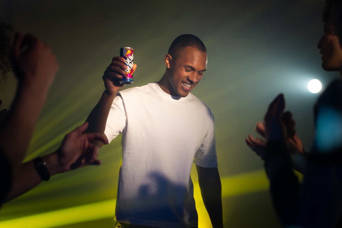 Man dancing at a party with a BUM BUM Energy Drink can